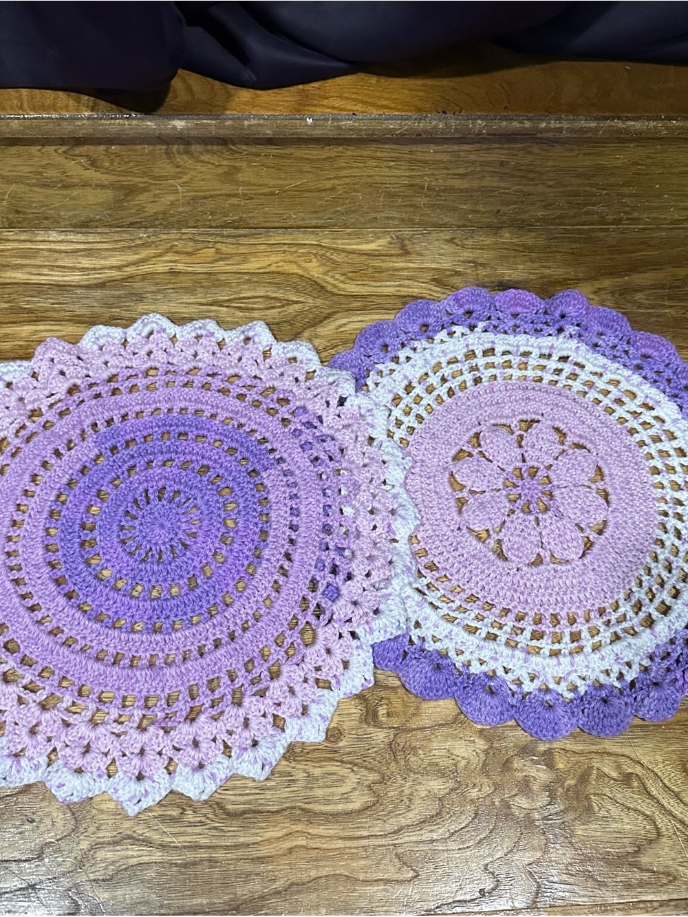 Two crocheted purple doilies